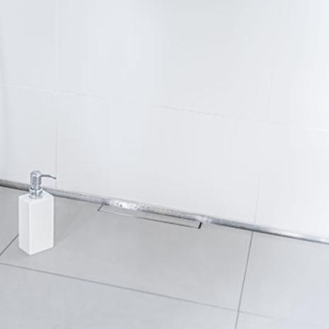 Exemple d'assainissement d'une salle de bains couloir : une douche sans obstacle dans les locaux de l'association « W4H » grâce à « CeraWall » de Dallmer